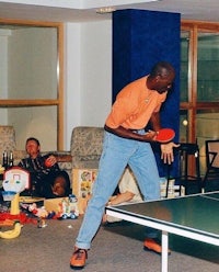 a man playing ping pong in a living room