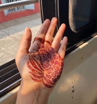 a woman's hand with henna on it on a bus