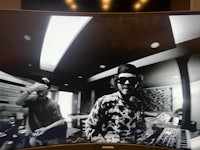 a man in sunglasses is standing in front of a tv