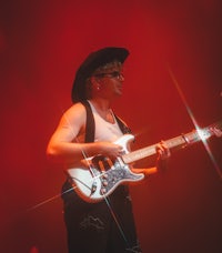 a man in a cowboy hat playing an electric guitar
