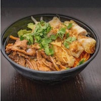 a bowl of noodles with meat and vegetables in it