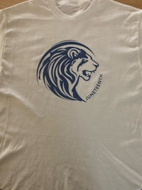 a white t - shirt with a lion on it