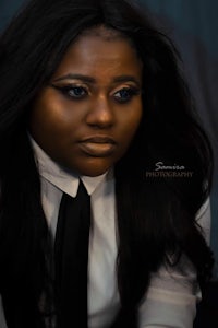 a black woman in a white shirt and tie