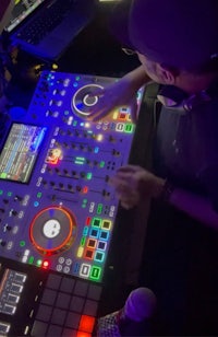 a dj is playing a dj mixer in a club