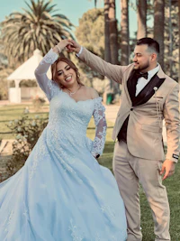 a bride and groom dancing in a park