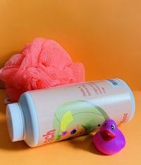 a bottle of bubble bath with a rubber duck next to it