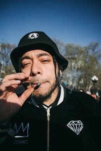 a man wearing a hat smoking a cigarette