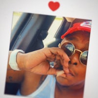 a man wearing sunglasses and a hat is smoking a cigarette