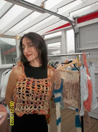 a woman standing in front of a rack of clothes