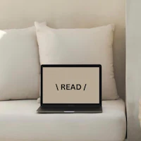 a laptop with the word read on it sitting on a couch