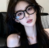 a young woman wearing glasses on a couch