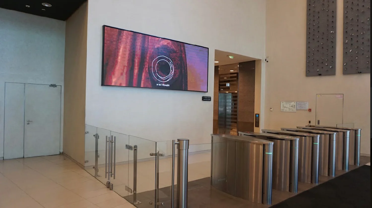 a large tv mounted on a wall in a lobby