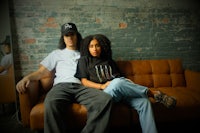 a man and woman sitting on a brown couch