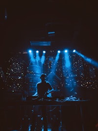 a dj is playing music in a dark room