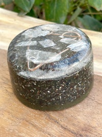 a small box with a lid sitting on top of a wooden table