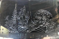 a black plate with a picture of a city on it