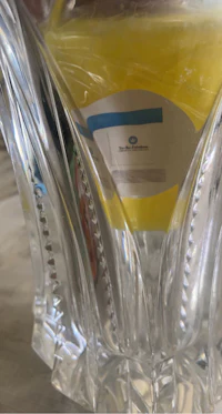 a glass vase with a yellow label on it