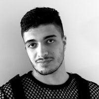 a black and white photo of a man wearing a mesh top