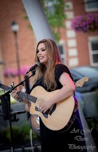 image may contain person, on stage, playing a musical instrument and guitar