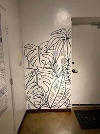a black and white drawing of tropical plants on a wall