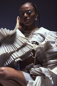 a woman in a white dress is posing for a photo