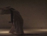 a woman in a white dress is standing in the dark