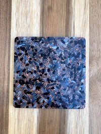 a blue and black marble coaster on a wooden table