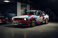 a bmw e30 m3 is parked in a garage