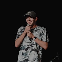 a man in a camouflage shirt holding a microphone