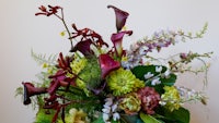 an arrangement of flowers in a vase on a table
