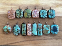 a group of turquoise and copper pendants on a wooden table