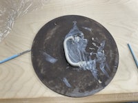 a metal plate with a paint brush on it