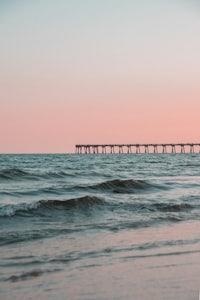 a pier in the ocean at sunset