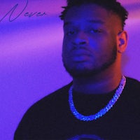 a man in a black shirt with chains in front of a purple background