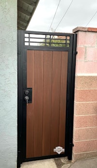a wooden gate with a black metal frame