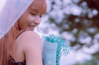 a girl wearing a veil and holding a bouquet of flowers