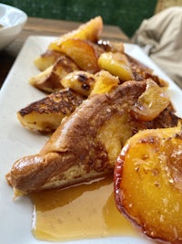 a plate of french toast with peaches on it