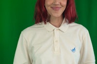 a woman with red hair wearing a polo shirt