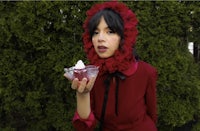 a woman in a red dress holding a dessert