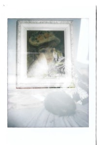 a framed picture of a woman with a hat