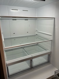 a refrigerator with a glass door and open shelves