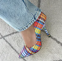 a woman wearing a colorful plaid high heeled shoe