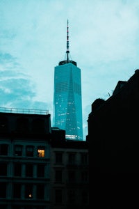 a skyscraper with a clock tower in the background