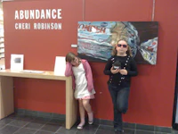 two women laying on the floor in front of a painting