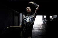 a woman in a skeleton bodysuit holding a guitar