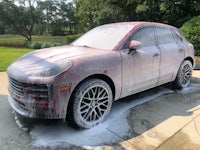a porsche macan being washed on a driveway