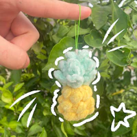 a person is holding a pineapple ornament in front of a tree