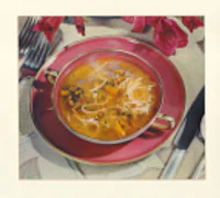 a bowl of soup on a plate with a fork