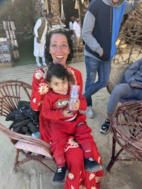 a woman in a red dress holding a child