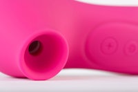 a pink vibrator on a white surface